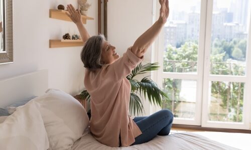 Woman in senior living home in front of window emphasizing natural lighting, circadian rhythm in study.