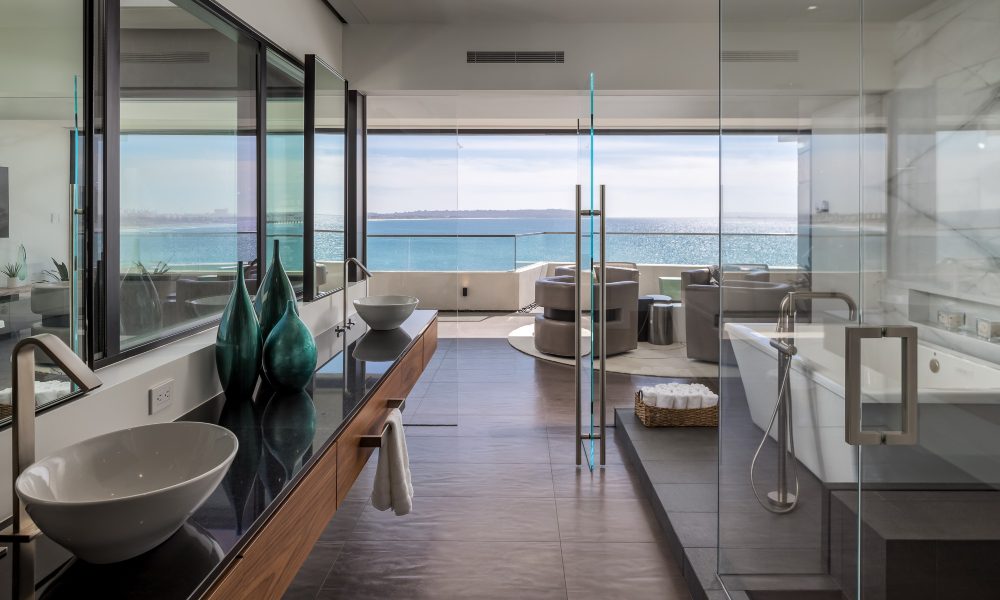 Interior of the seaside home looking out onto the beach while also showcasing the concealed cassettes for the motorized shading systems.