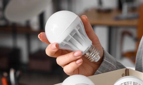 Picture of hand holding LED light over packaging material meant to represent what circadian lighting researchers are targeting with blue light warning labels.