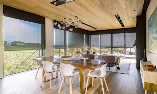 Interior dining room. System 7 motorized shades integration project. Rhode Island. Dark fabric with ocean in the background.