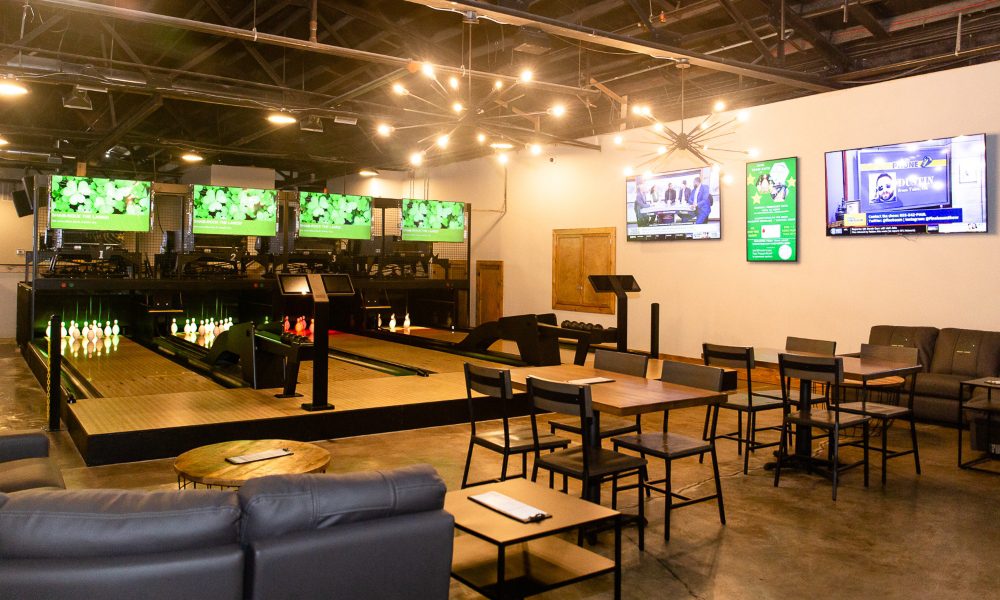 Bowling alley in sports bar lit with elaborate lighting fixtures