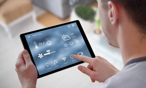 Man using ventilation controls on a smart home control pad to represent new CDC air quality guidelines.