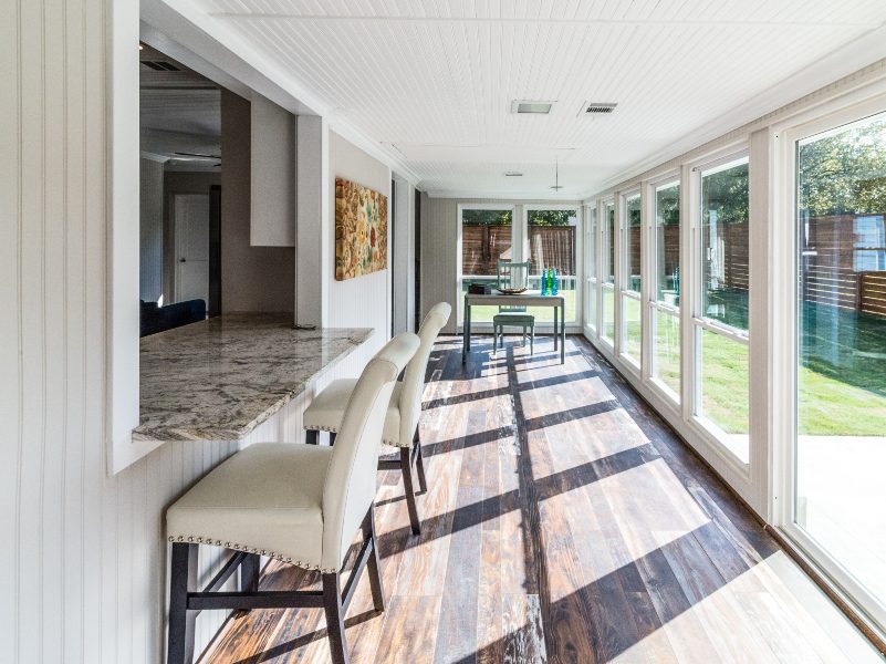 Natural lighting flowing onto interior sunroom with kitchen bar.