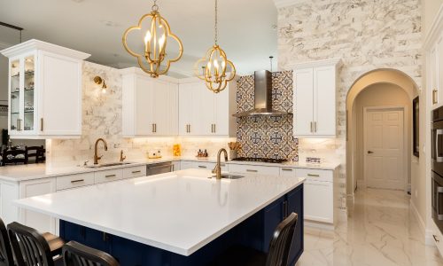 Interior of a white, modern kitchen with ample lighting throughout to highlight the topic of Lutron Lighting Report.