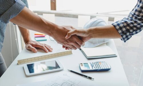 Two tradesmen shaking hands meant to represent an integrator and electrician on a project.