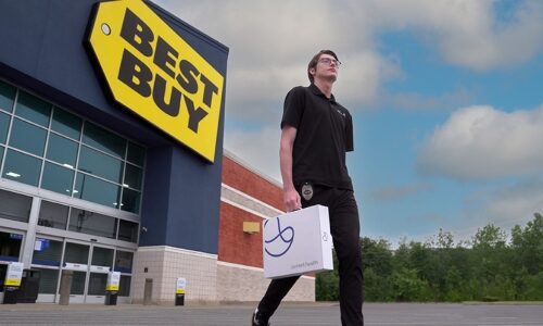 Promotional image of Geek Squad employee distributing Best Buy Home Health services.