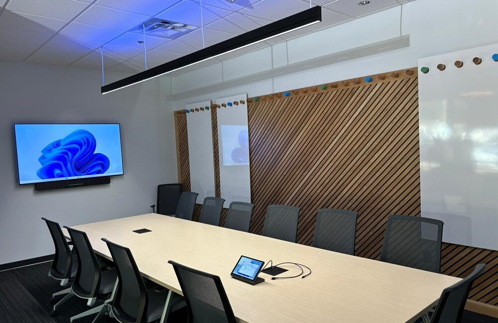 Office space with LG display and overhead KSCAPE RAIL Lighting with blue uplights.