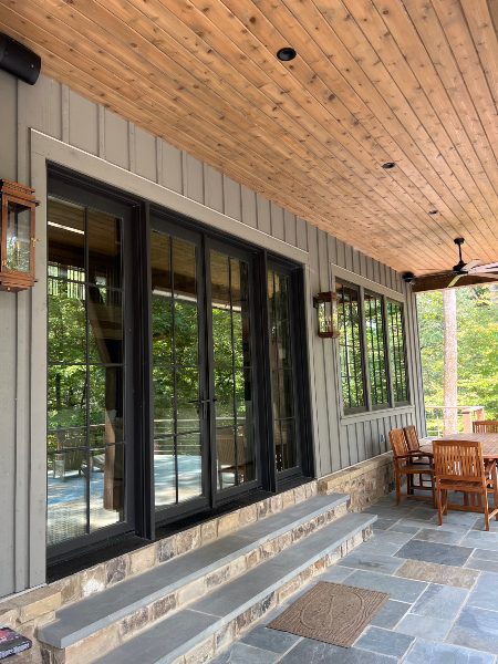 Outside lakeside retreat Killen Alabama custom motorized shading pulled up Mozaic Integrated Technology Design