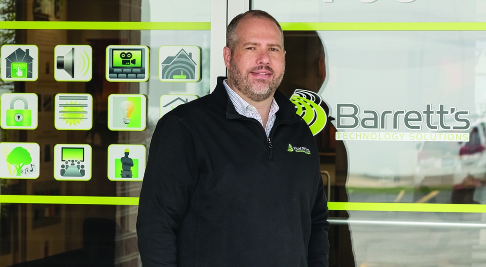 Brian Perreault standing in front of the entrance into Barrett's Technology Solutions showroom.