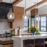 Modern luxury kitchen in a Colorado home featuring integrated home automation, designer lighting, and natural wood cabinetry.