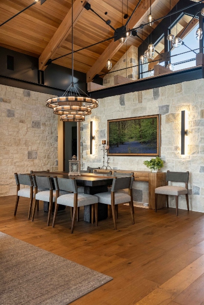 Modern luxury dining room in a Colorado home featuring integrated home automation, designer lighting, and natural wood cabinetry.