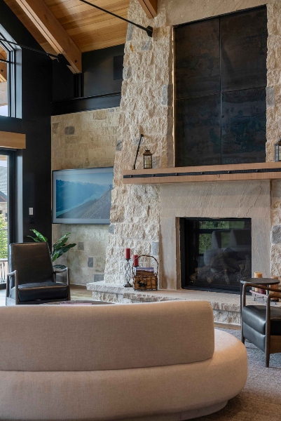 Luxury Colorado home interior showcasing integrated smart lighting, natural stone wall in modern rustic design.