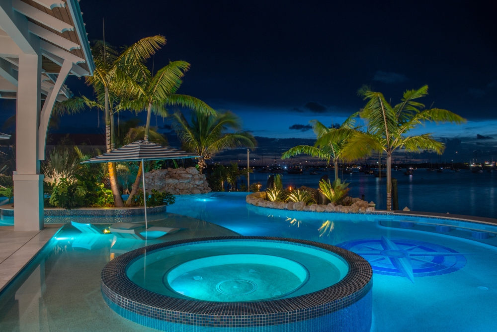 Cool green glow of underwater lighting in coastal pool at Harbor Palms coastal contemporary property with slight art deco touches