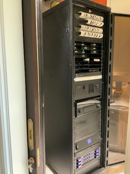 Organized server room housing the backbone of the home’s AV, networking, and automation systems by Macbee PVT.