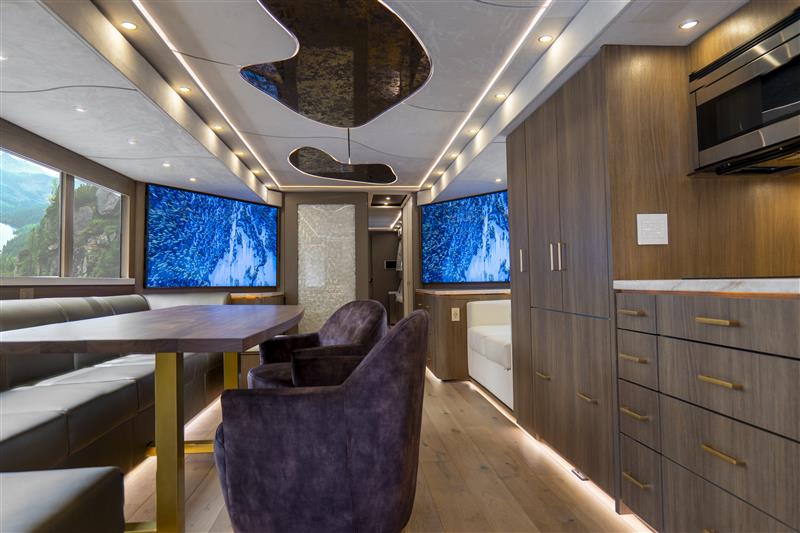 Retro-style RV interior with flowing ceiling details and under cabinet lighting.
