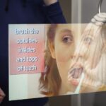 Séura mirror TV displaying step-by-step hygiene instructions in the CARES House bathroom, part of an assistive living system designed to support independence for autistic students.