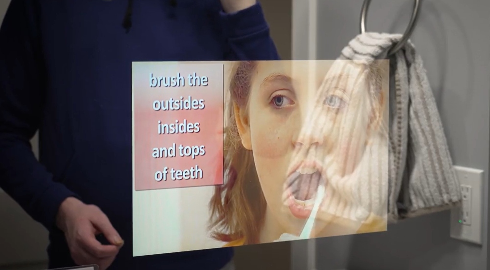 Séura mirror TV displaying step-by-step hygiene instructions in the CARES House bathroom, part of an assistive living system designed to support independence for autistic students.