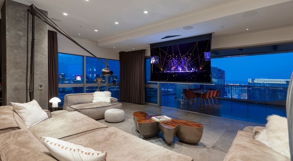 Motorized drop-down screen in Las Vegas penthouse home theater with skyline view behind screen