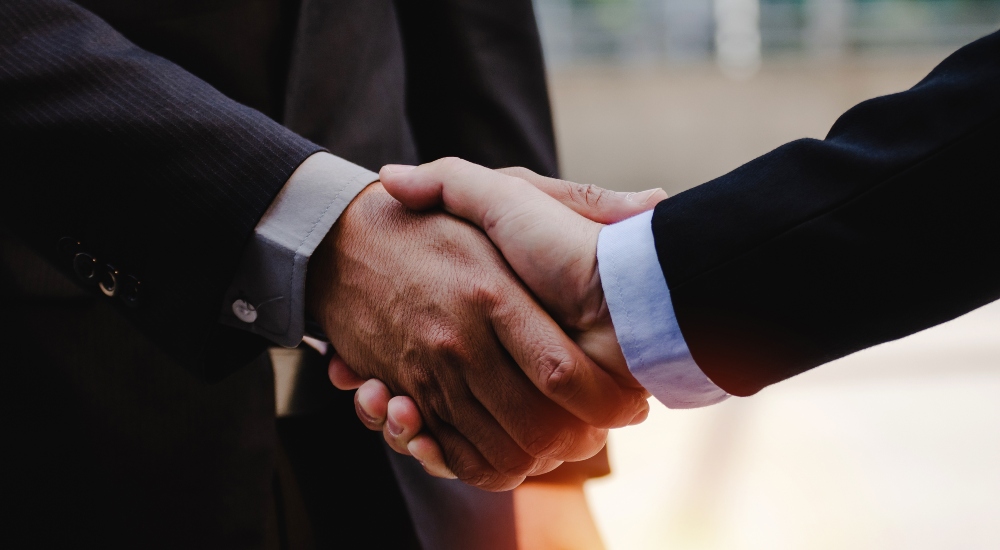 Business partner handshake meant to represent topic in Week in Playback weekly news segment for custom integration