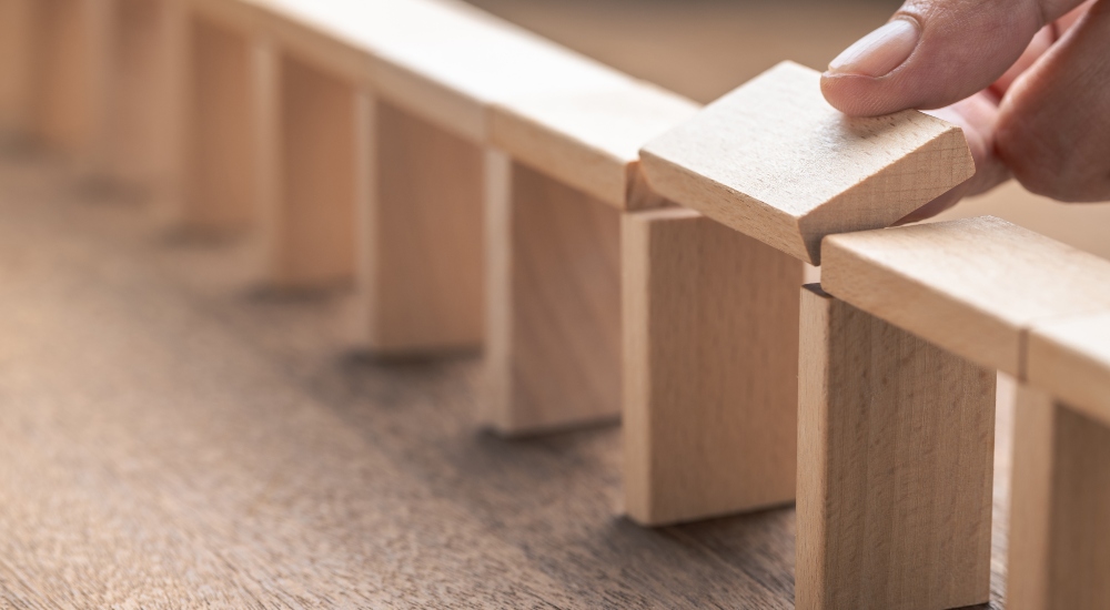 Closeup hand that building the wooden pieces as a bridge, and going to fill the gap with the last piece, gap and disconnect problem, solution to solve it, build success