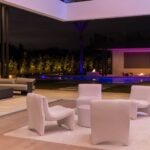 Interior living space with outdoor lighting in the distance, creating a natural extension of the home into a cohesive living environment