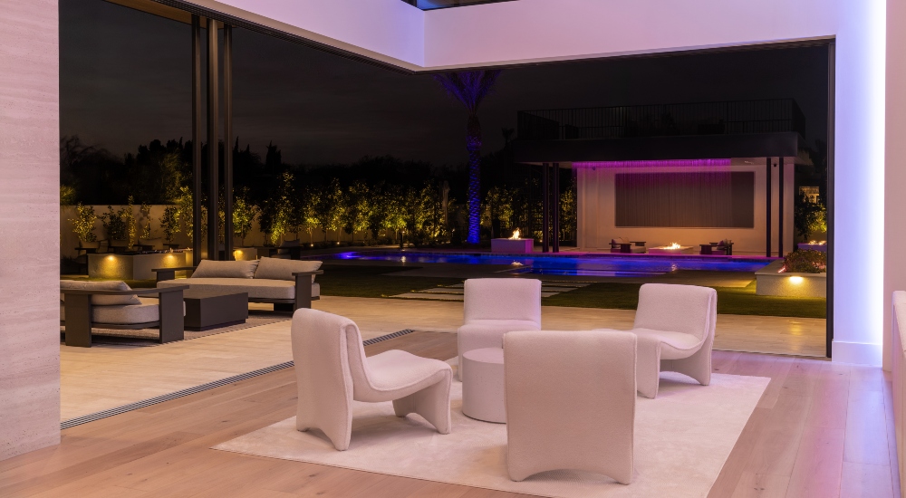 Interior living space with outdoor lighting in the distance, creating a natural extension of the home into a cohesive living environment