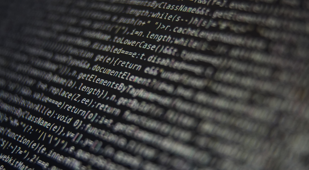 White Program Source Code Segment on Black Screen Closeup