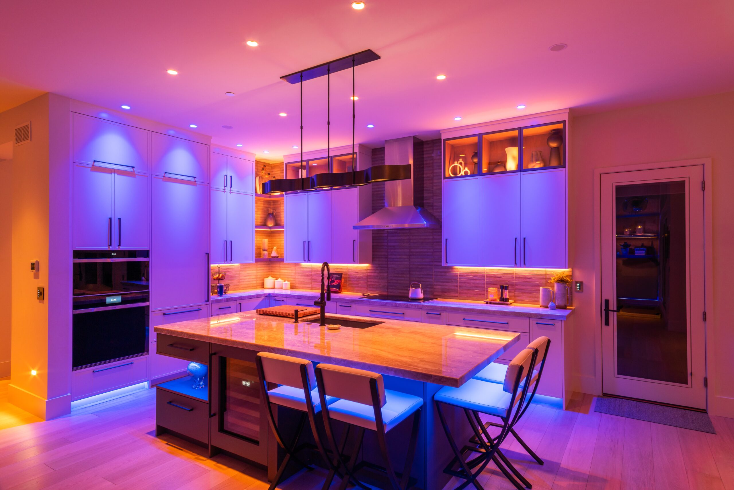 Decorative lighting fixtures paired with color tunable lighting in a colorful kitchen