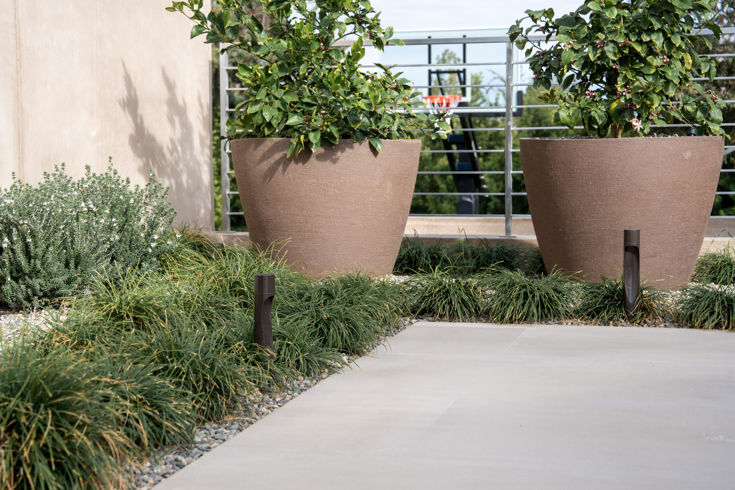 Softly lit residential walkway at a luxury Palo Alto smart home featuring integrated path lighting programmed as part of AudioVisions' whole-home Lutron exterior lighting control system