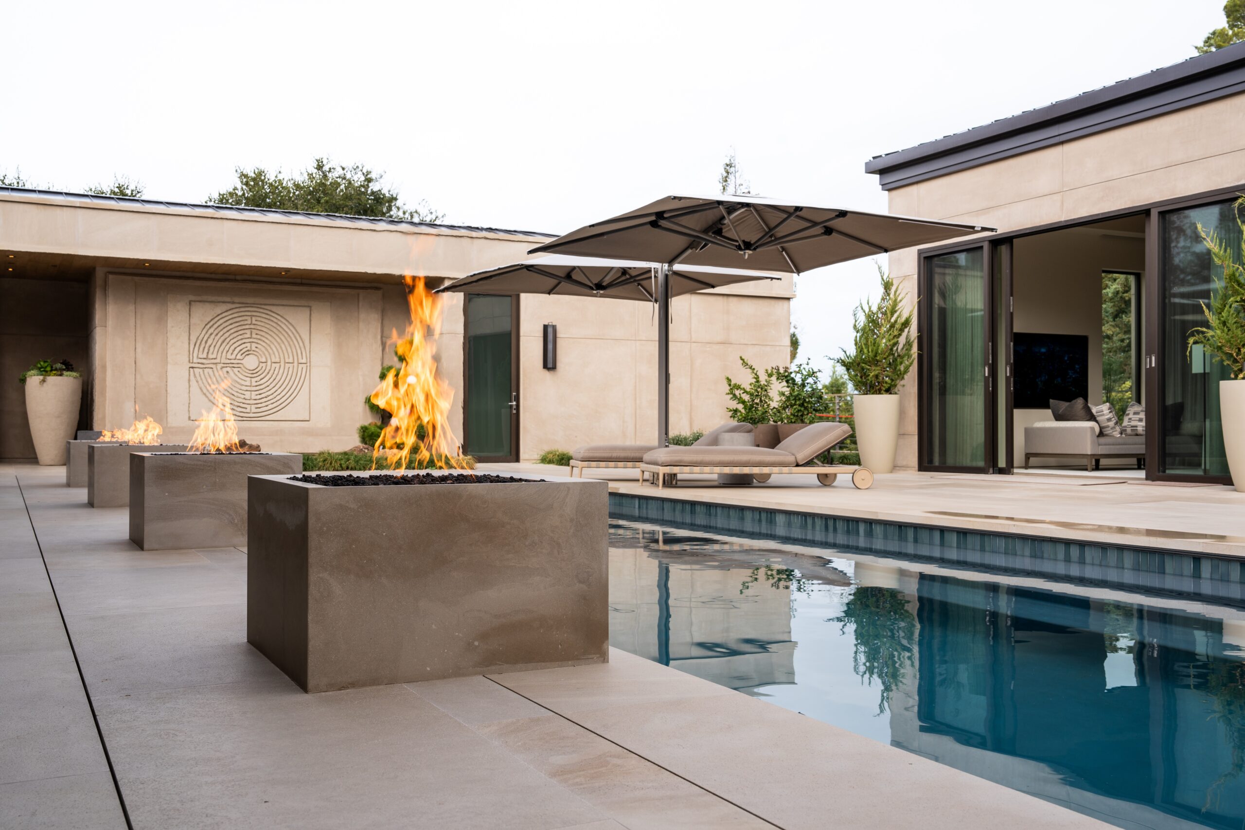 Wide exterior shot of a luxury Palo Alto residence pool area at dusk featuring layered outdoor lighting scenes integrated into the whole-home automation system designed and installed by AudioVisions
