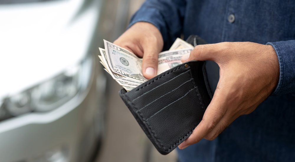 Man pulling money out of wallet as an example of U.S. consumer discretionary spending habits