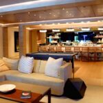 Wide view of a luxury smart home living room in Palo Alto California featuring concealed television integration behind architectural millwork, installed as part of a whole-home Savant and Lutron HomeWorks automation system by AudioVisions